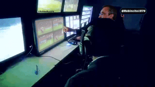 Man Sitting in Front of Monitors With Robincito 1976 Sticker