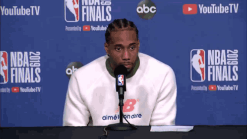 Man Sitting In Front Of NBA Finals Banner GIF