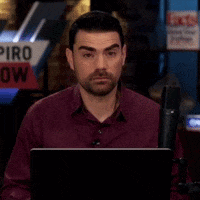 Man Sitting In Front Of Piro Show Sign GIF