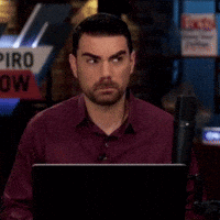 Man Sitting In Front Of Piro Sign GIF