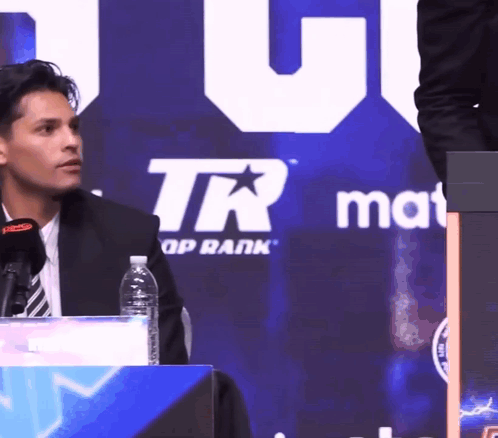 Man Sitting in Front of TR Group Rank Sign