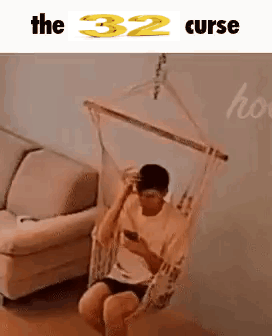 Man Sitting in Hammock Looking at Phone