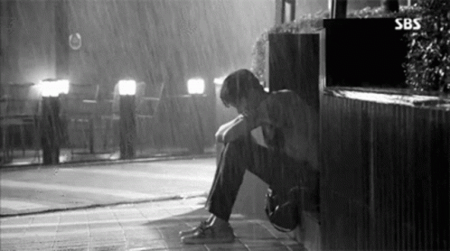 Man Sitting In Rain With Head Down GIF