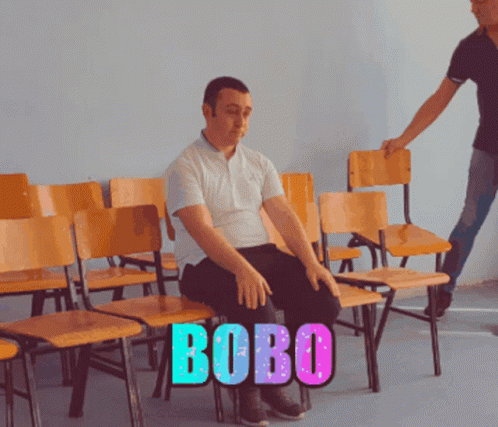 Man Sitting in Row of Chairs With Bobo