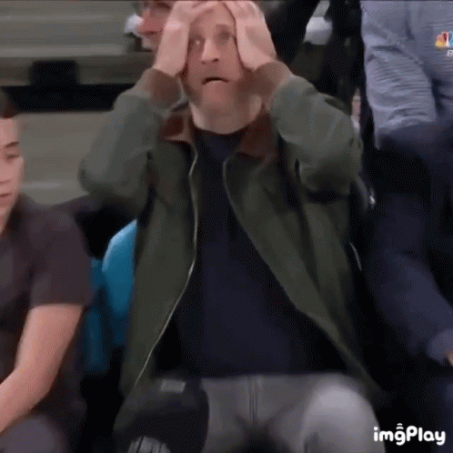 Man Sitting In Stadium With Hands On Head Surprised GIF
