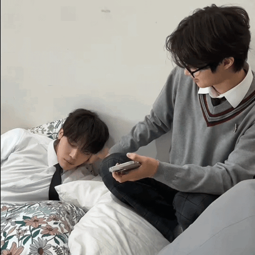 Man Sitting Next to Sleeping Man