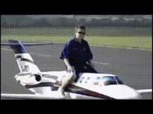Man Sitting Next to Small Airplane N20