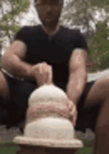 Man Sitting on Bench Holding Cake