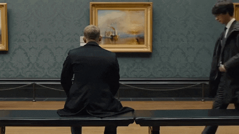 Man Sitting on Bench in Front of Painting