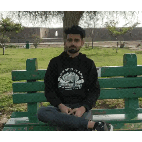 Man Sitting On Bench With Adventure Club