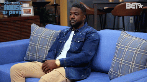 Man Sitting on Blue Couch in House of Payne Scene