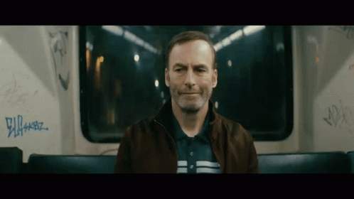 Man Sitting on Bus With Graffiti