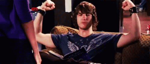 Man Sitting on Couch Flexing Muscles