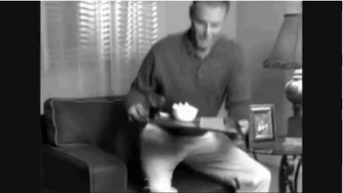 Man Sitting on Couch Holding Food Tray