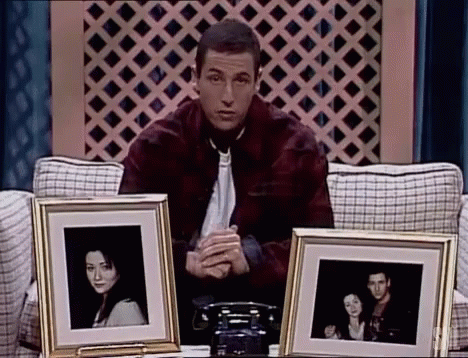 Man Sitting on Couch Holding Framed Photos