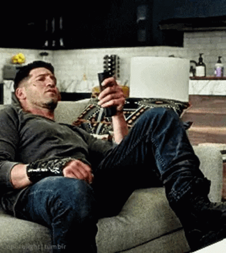 Man Sitting on Couch Holding Remote