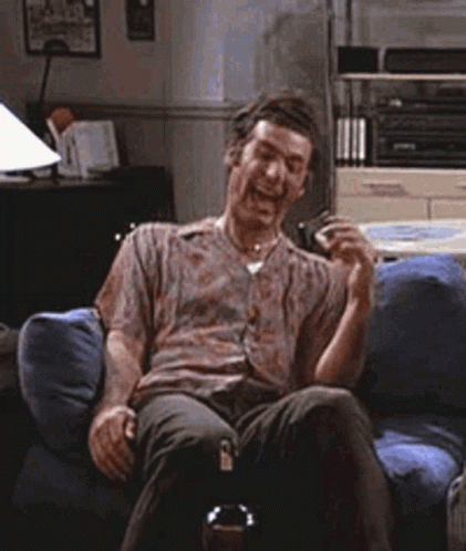 Man Sitting On Couch Laughing With Beer GIF