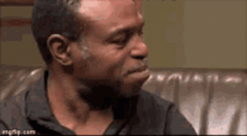 Man Sitting on Couch Mouth Open Looking