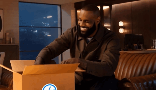 Man Sitting on Couch Opening Box With Blue Circle