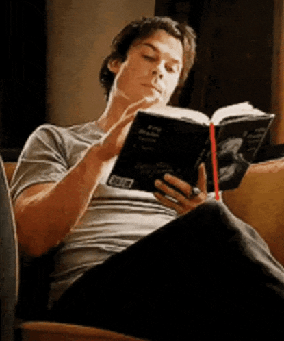 Man Sitting on Couch Reading Book With Ring