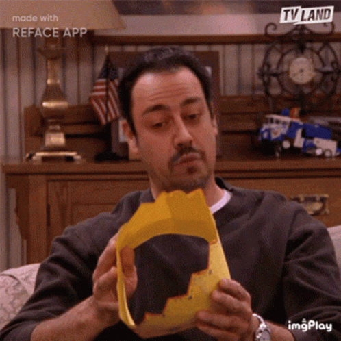 Man Sitting on Couch Reading TV Land Paper