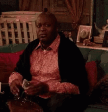 Man Sitting on Couch Smoking Cigarette Drinking Wine