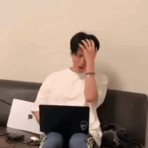 Man Sitting On Couch Using Laptop Holding His Head GIF
