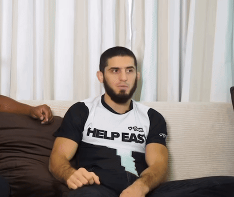 Man Sitting On Couch Wearing Help Easy Shirt GIF
