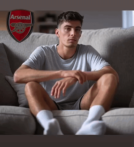 Man Sitting on Couch With Arsenal Logo