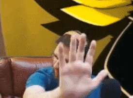 Man Sitting On Couch With Hand Up GIF