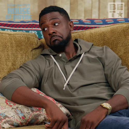 Man Sitting on Couch With House of Payne Poster