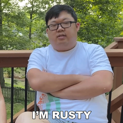 Man Sitting on Deck With Arms Crossed Saying I'm Rusty