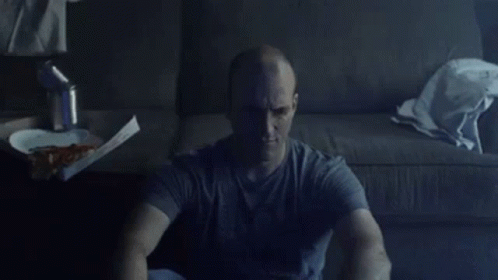 Man Sitting on Floor With Box of Pizza