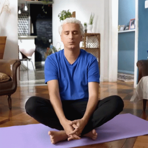 Man Sitting on Purple Yoga Mat Eyes Closed