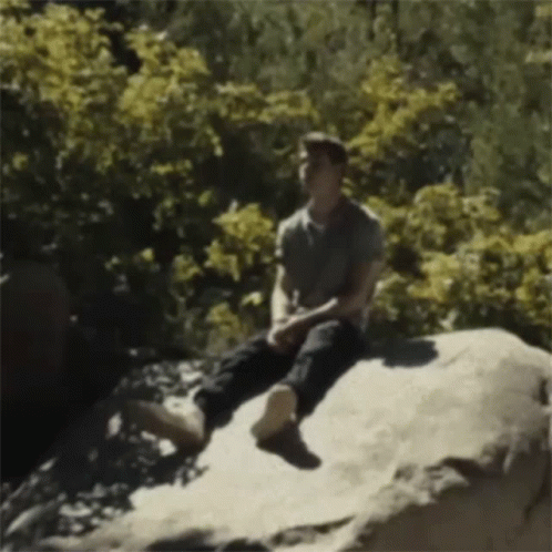 Man Sitting on Rock in Woods