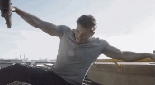 Man Sitting on Roof With Arms Outstretched
