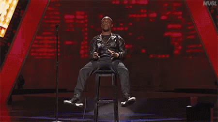 Man Sitting on Stage with Microphone