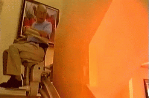 Man Sitting on Stair Lift With Painting Behind
