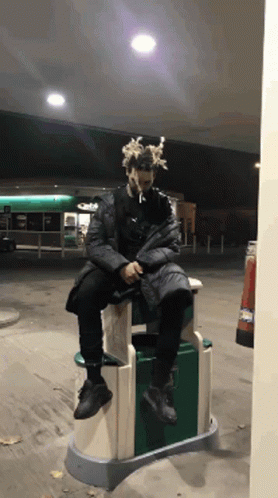 Man Sitting on Trash Can Smoking