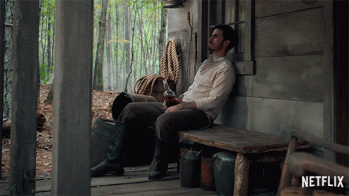 Man Sitting on Wooden Bench in Front of Netflix Sign