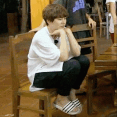 Man Sitting on Wooden Chair Wearing Sandals