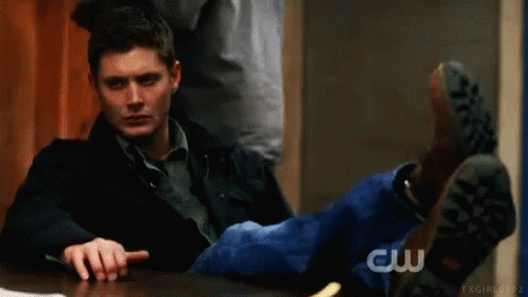 Man Sitting With Feet Up Pointing At Camera GIF