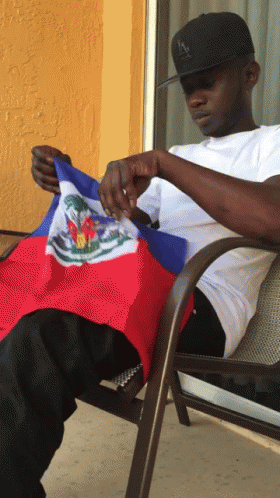 Man Sitting with Haitian Flag