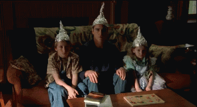 Man Sitting With Two Children in Tin Foil Hats