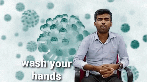 Man Sitting With Wash Your Hands Sign