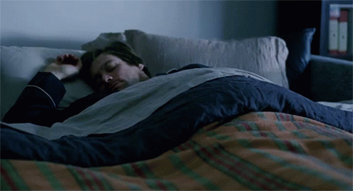 Man Sleeping in Bed with Plaid Blanket