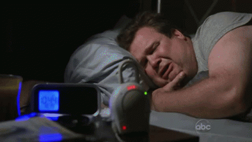 Man Sleeping Next to Alarm Clock