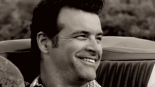 Man Smiling in Black and White Convertible Car