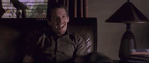 Man Smiling in Chair in Dark Room