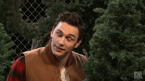 Man Smiling in Front of Christmas Tree